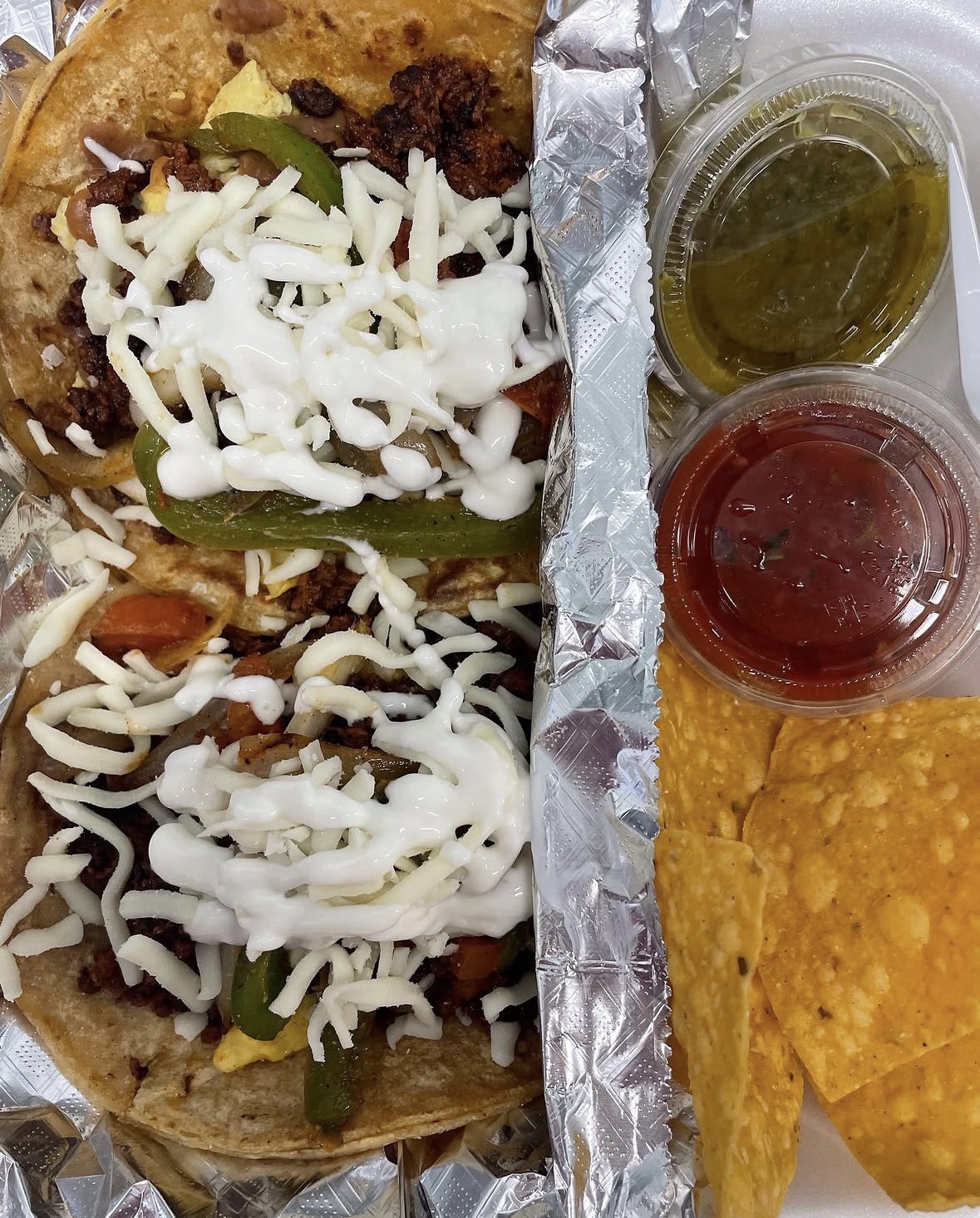 Loaded tacos with cheese, sour cream and salsa on the side